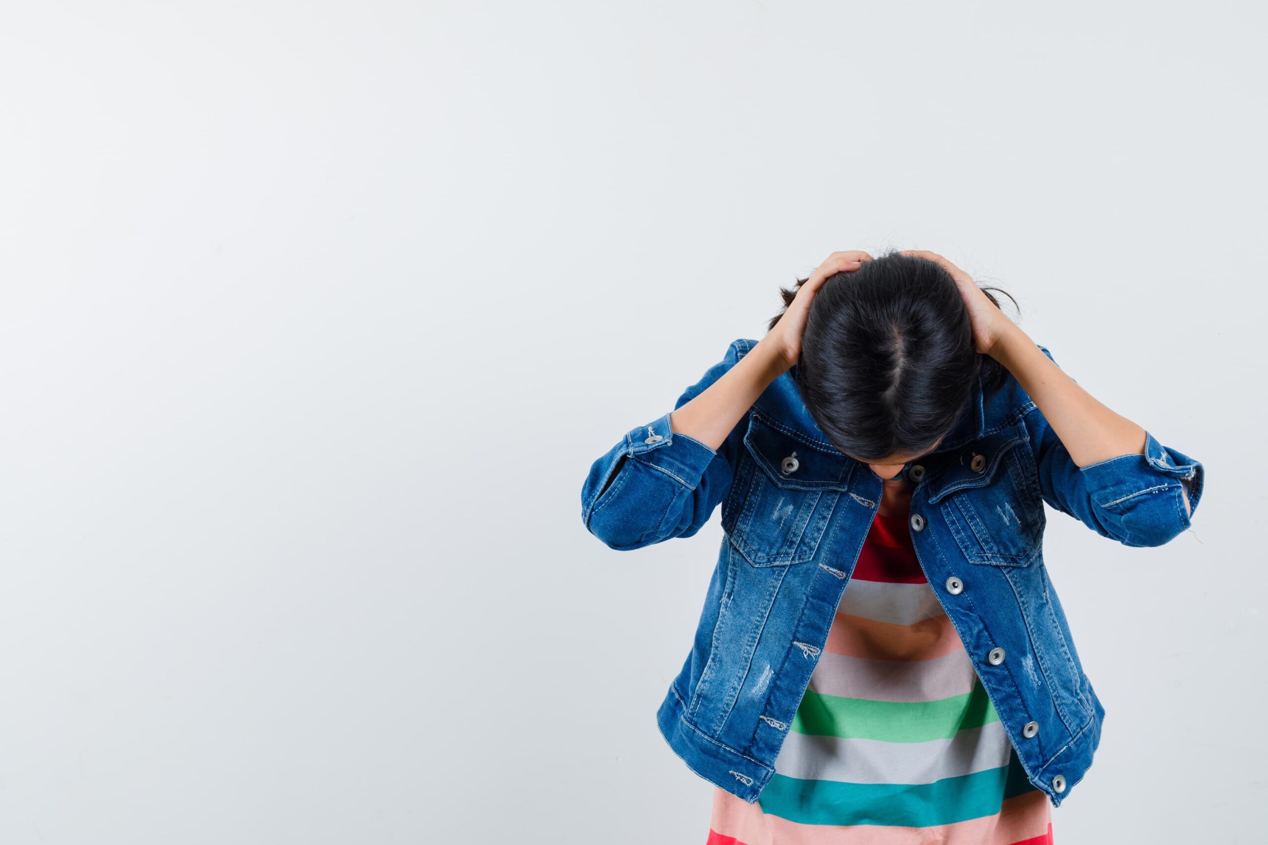 teenage girl bending her head holding back her head with hands white background 1 scaled